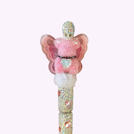 Handgemaakte glitterpen met zilveren strass, roze vlinderbeer en hartje, versierd met fluffy details – uniek cadeau voor meisjes.