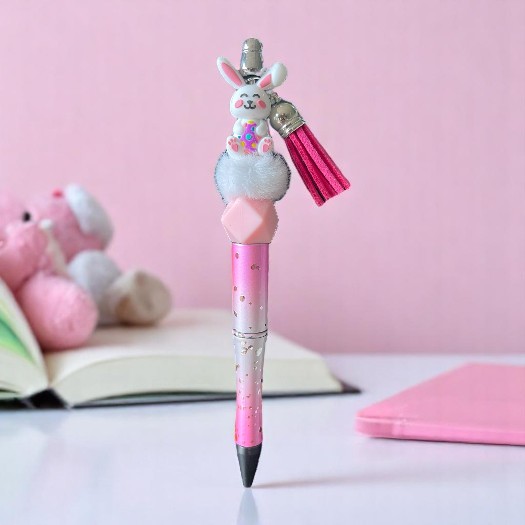 DIY-pen met wit siliconen konijntje en kleurrijk paasei, gecombineerd met een zachte fluffy pompon – perfect als paasaccessoire of kindvriendelijk knutselproje