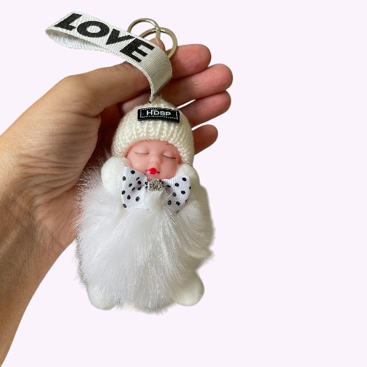 Witte fluffy sleutelhanger met slapend baby popje en LOVE-bandje – schattig accessoire voor sleutels of tassen